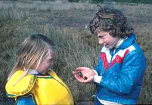 two girls look at a shore crab